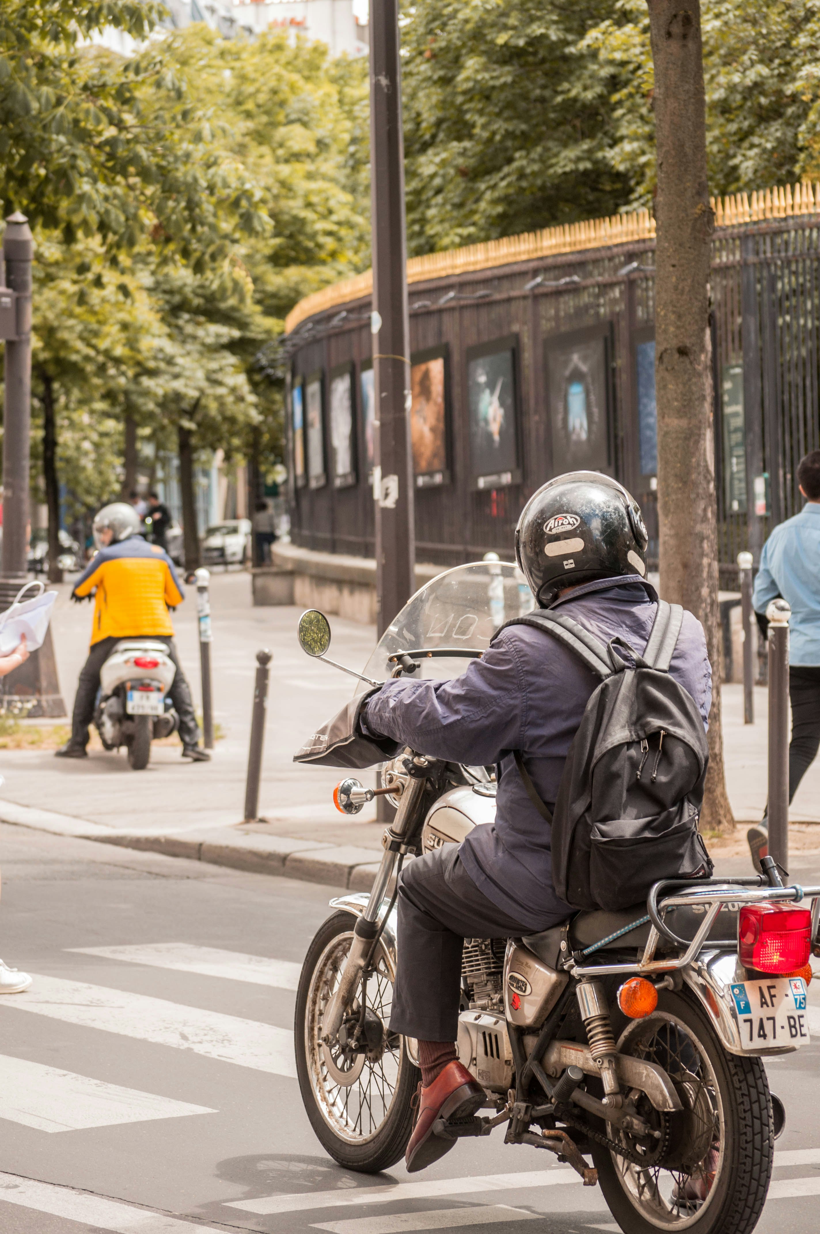 man in black jacket and helmet riding motorcycle on road during daytime